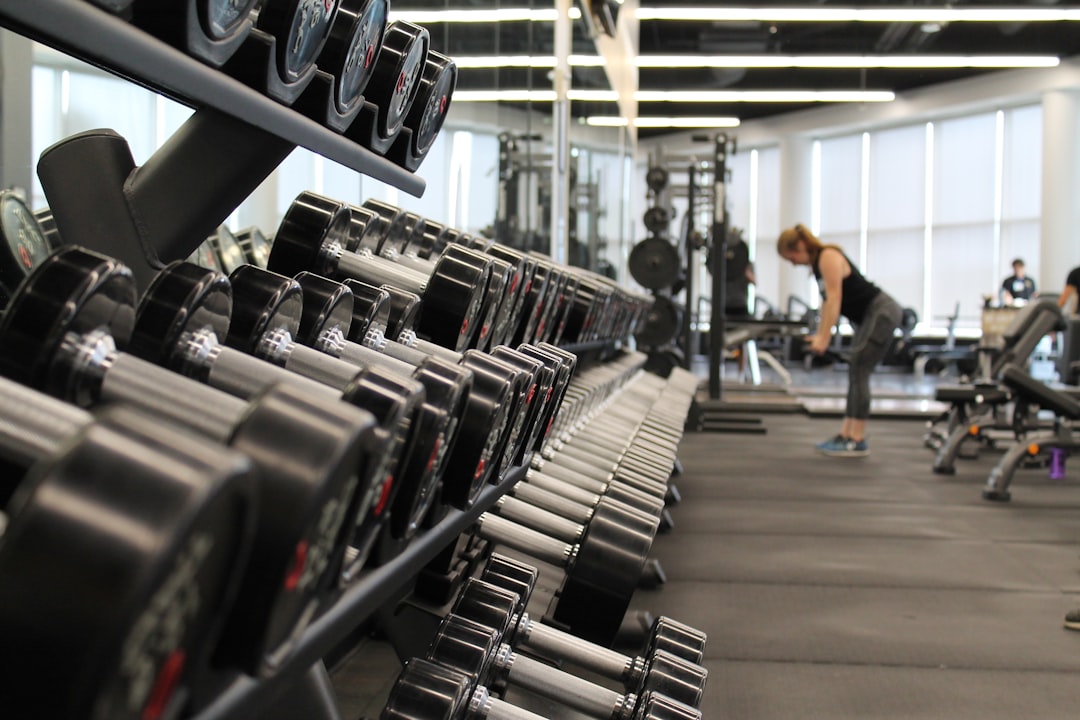 Woman standing surrounded by exercise equipment in PS Fitness Gym